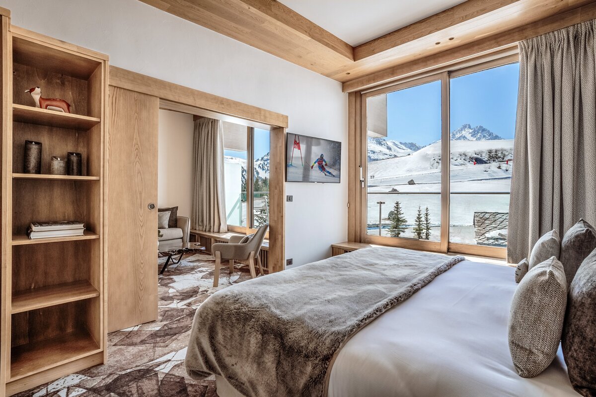 A bedroom with a painting of a skier on the wall