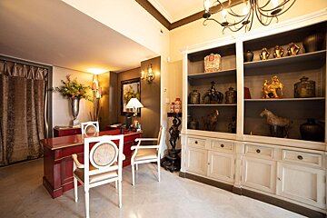 A room with a red desk and white chairs