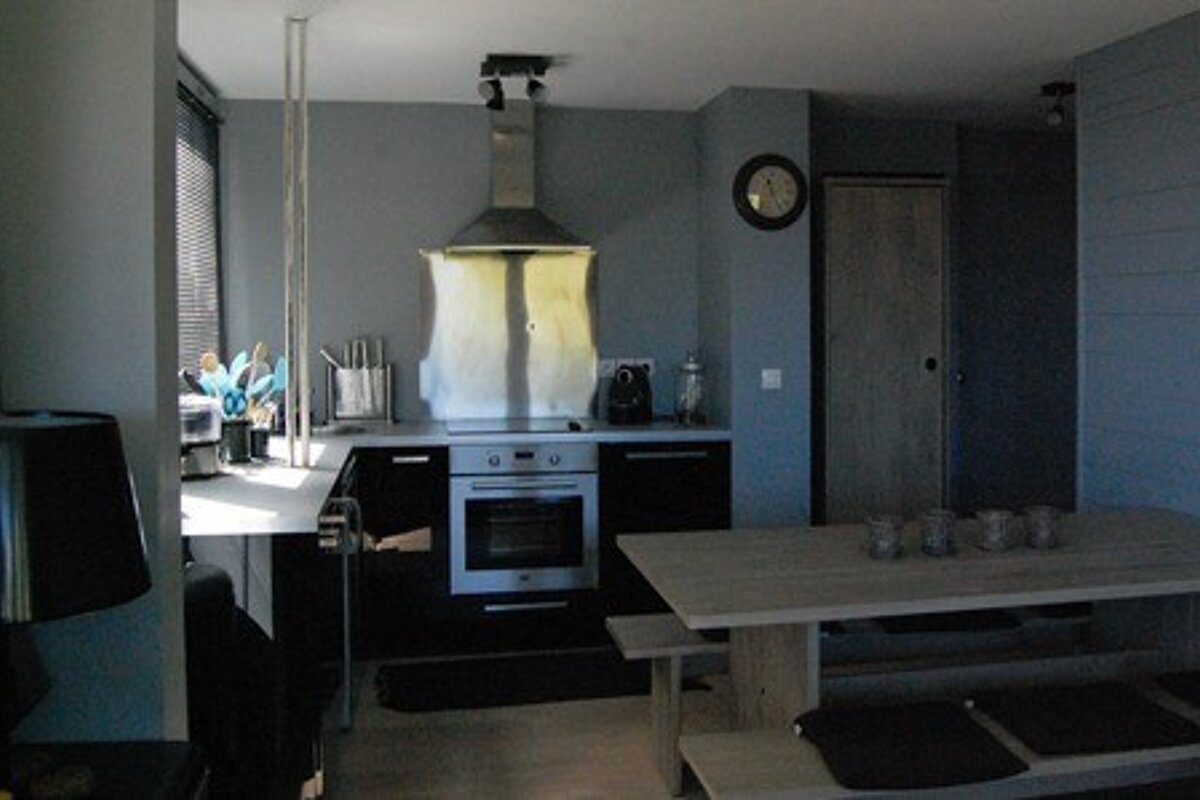 A kitchen with a table and a clock on the wall