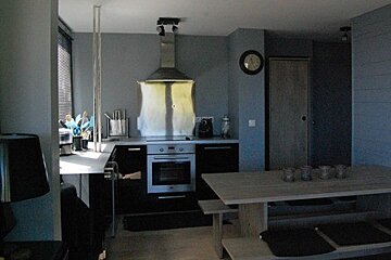 A kitchen with a table and a clock on the wall