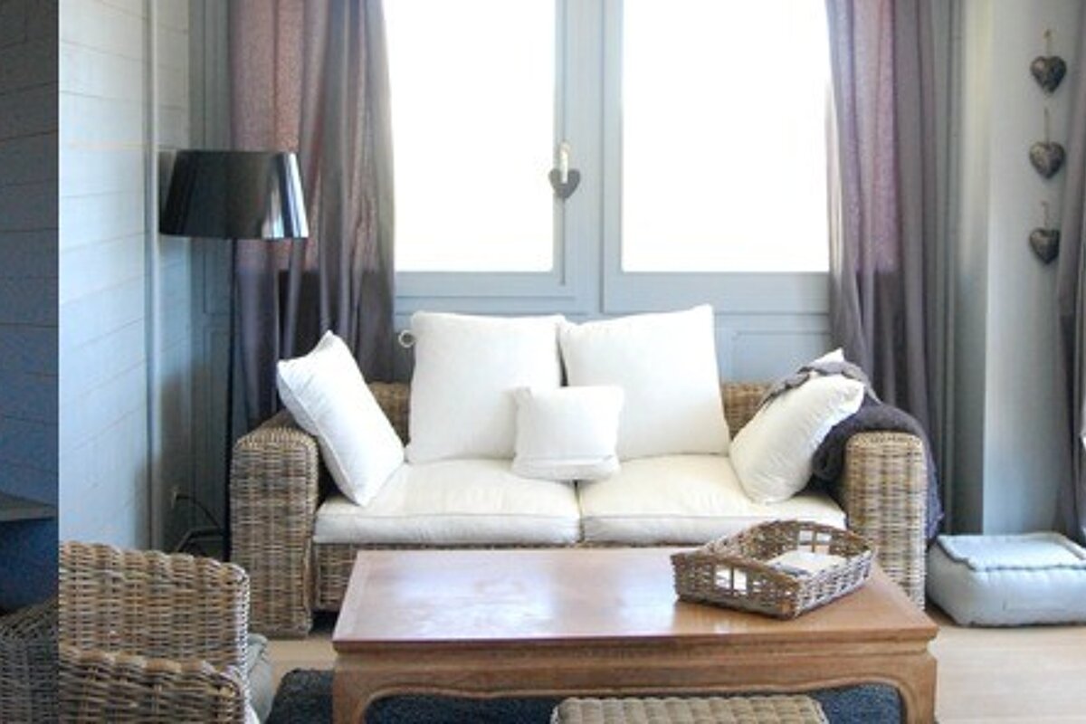 A living room with a wicker couch and a wooden coffee table