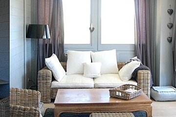 A living room with a wicker couch and a wooden coffee table