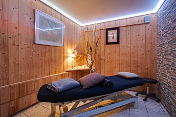 A massage table with a picture on the wall above it