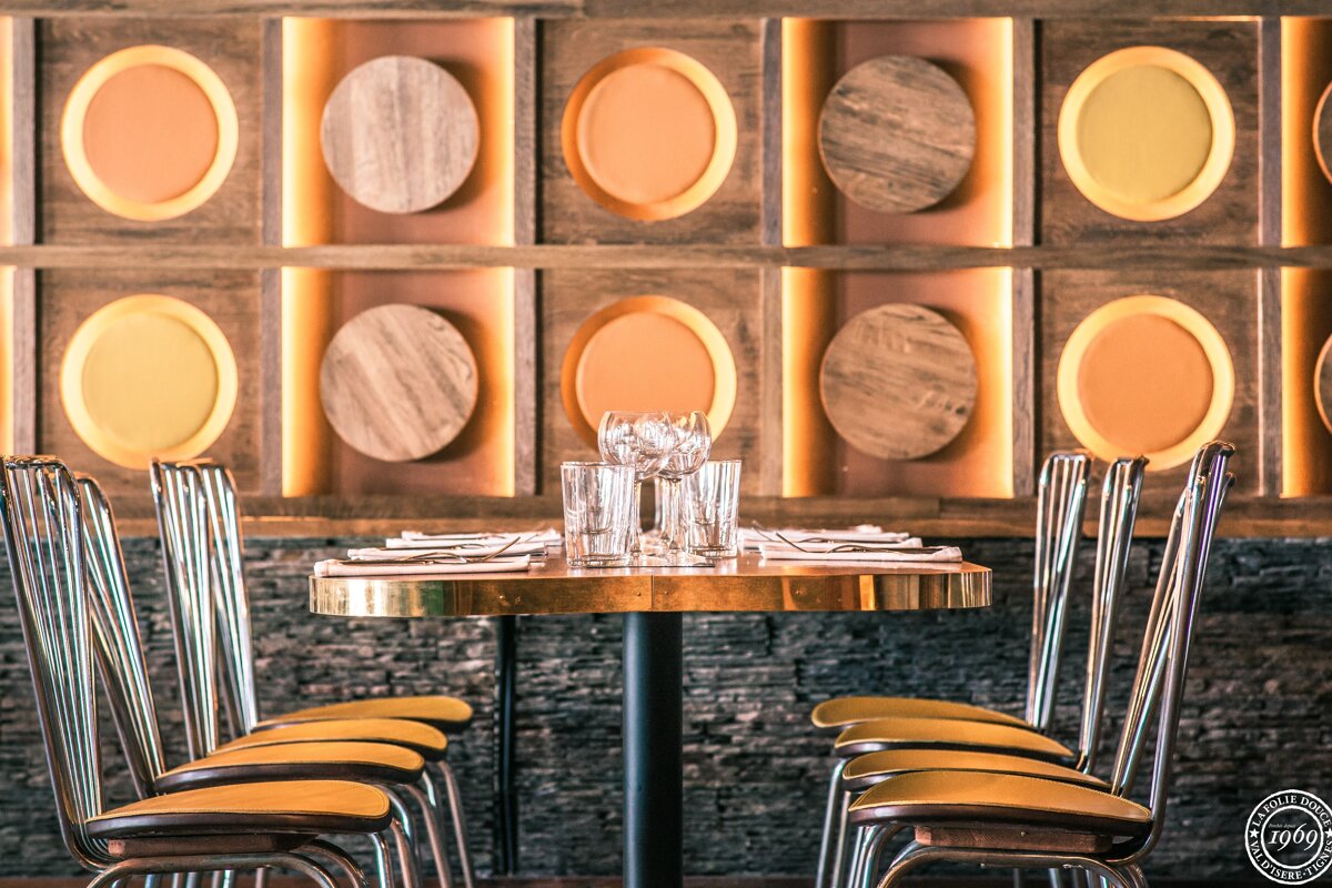 A row of chairs are lined up in front of a wall with circles on it