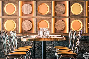 A row of chairs are lined up in front of a wall with circles on it