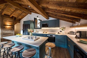 A kitchen with blue cabinets and wooden stools