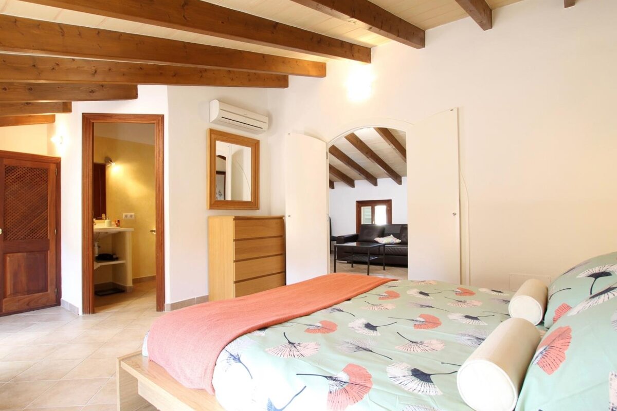 A bedroom with a large bed and a mirror