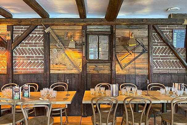 A restaurant with tables and chairs and a menu on the wall