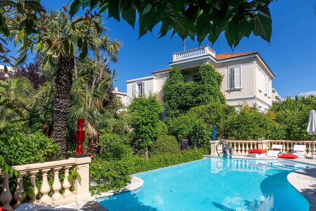 A large house with a swimming pool in front of it