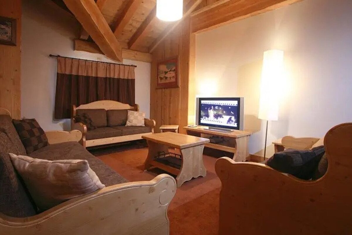A living room with wooden furniture and a flat screen tv