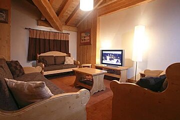 A living room with wooden furniture and a flat screen tv