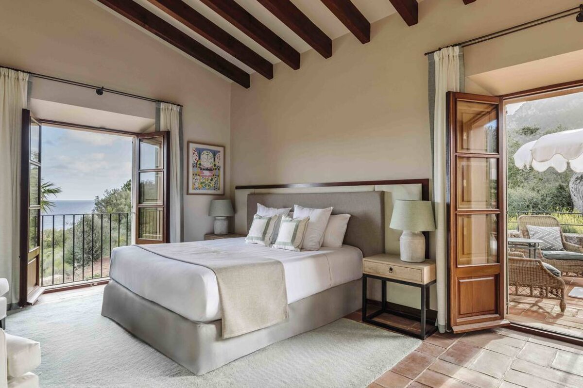 A bedroom with a large bed and a balcony