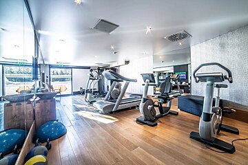 A gym with treadmills and exercise bikes and a sign that says exit