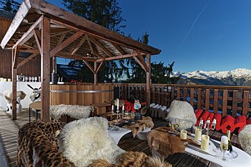 A wooden gazebo with a hot tub in the background