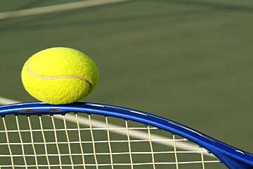 a tennis ball balancing on a racket