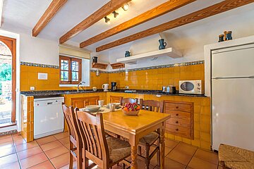 A kitchen with a table and chairs and a microwave