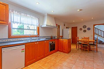 A kitchen with wooden cabinets and a white dishwasher