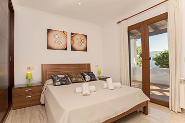A bedroom with a bed and two paintings on the wall