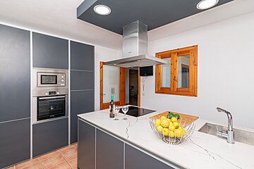 A kitchen with a bowl of lemons on the counter