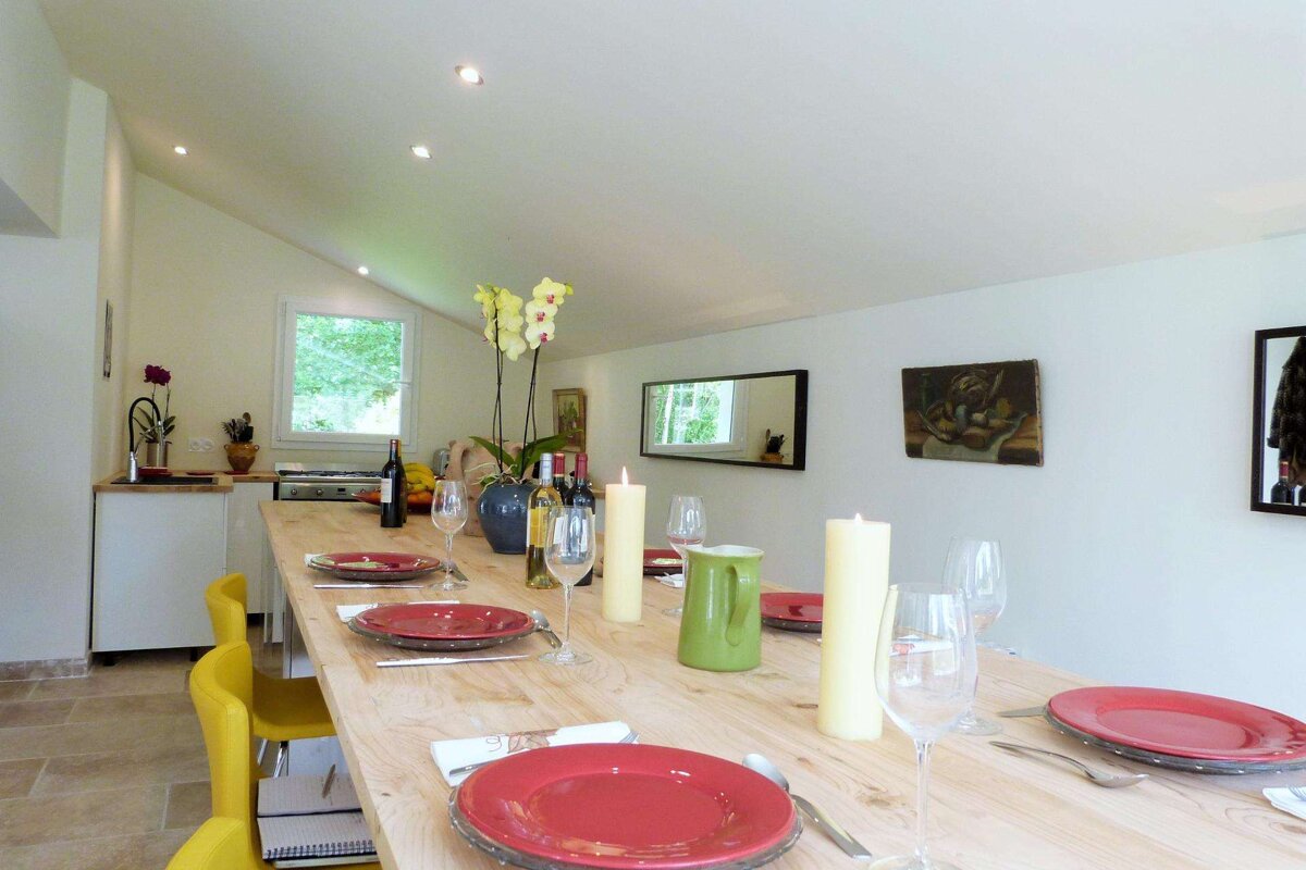 A long wooden table with plates and candles on it