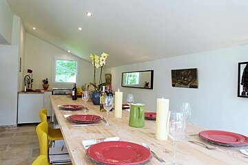 A long wooden table with plates and candles on it