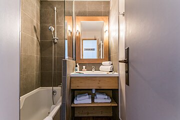 A bathroom with a sink a mirror and a bathtub