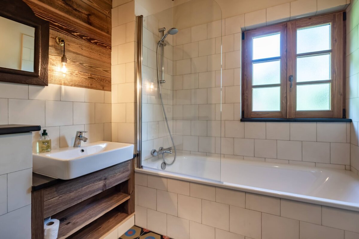 A bathroom with a sink and a bathtub and a window