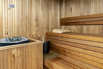 A wooden sauna with a sign on the wall that says