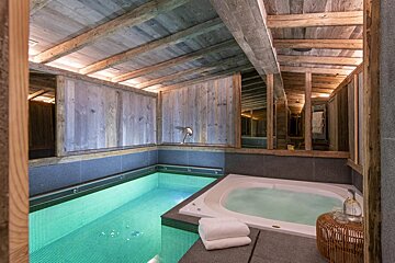 A bathtub in a room with a swimming pool