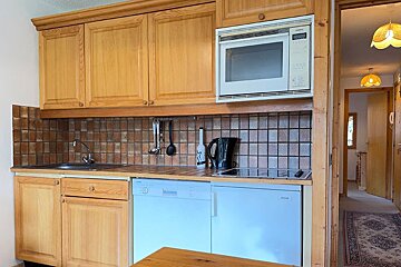 A kitchen with wooden cabinets and a siemens microwave