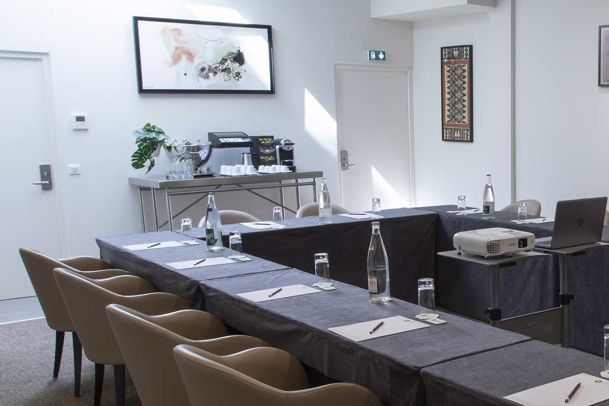 A conference room with tables and chairs and a projector