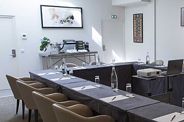 A conference room with tables and chairs and a projector