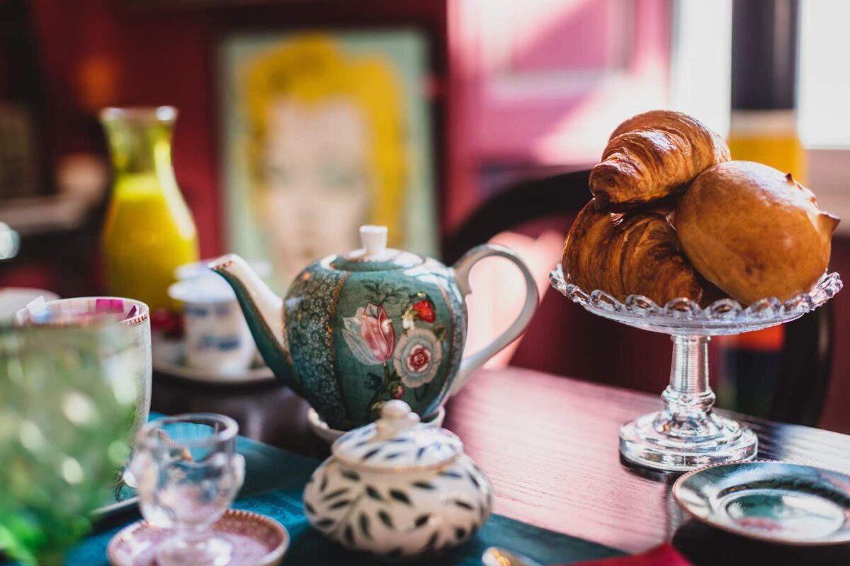 A table with a teapot and croissants on it