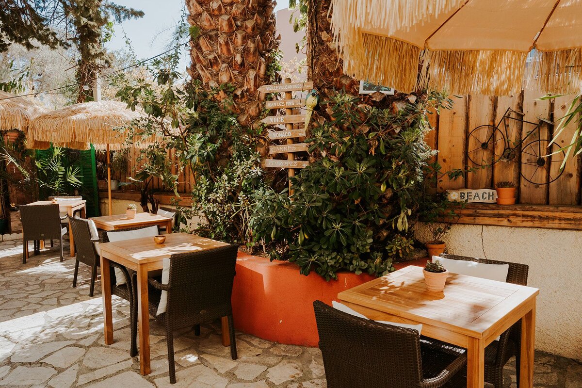 A sign that says beach hangs from a wooden fence
