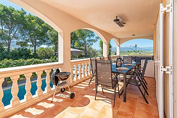 A balcony with a table and chairs and a grill