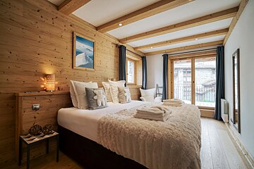 A bedroom with a bed and a picture on the wall