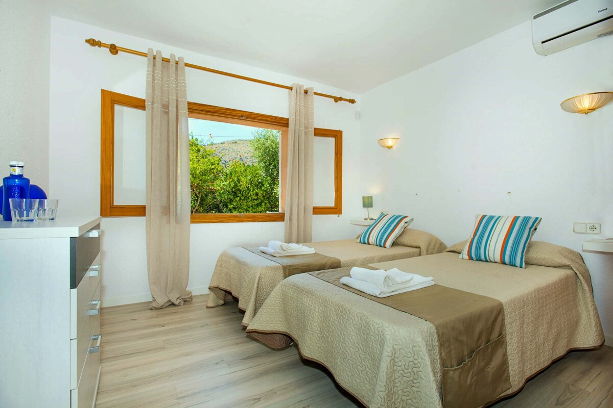 A bedroom with two twin beds and a window