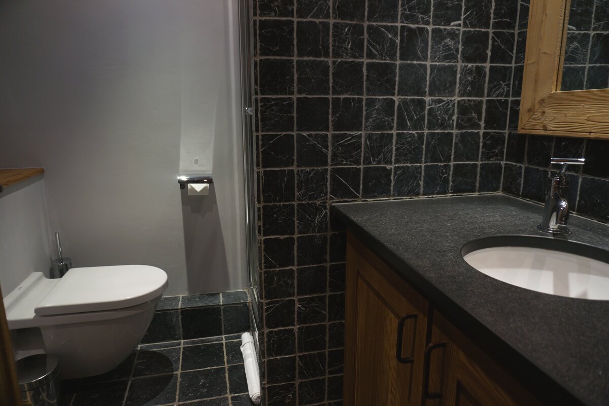 A bathroom with a toilet a sink and a mirror