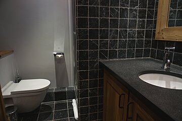 A bathroom with a toilet a sink and a mirror