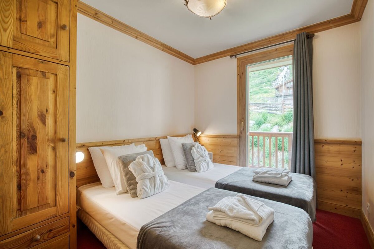 A bedroom with two beds and a window