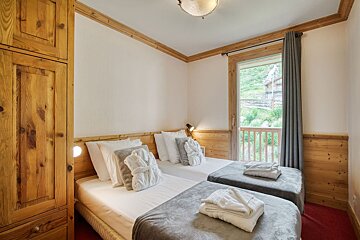 A bedroom with two beds and a window