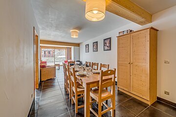 A dining room with a long table and chairs