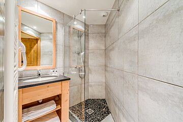 A bathroom with a walk in shower and a sink