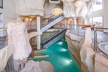 A swimming pool in a cave with stairs leading up to it