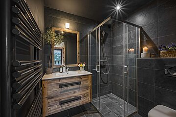 A bathroom with a sink and a walk in shower