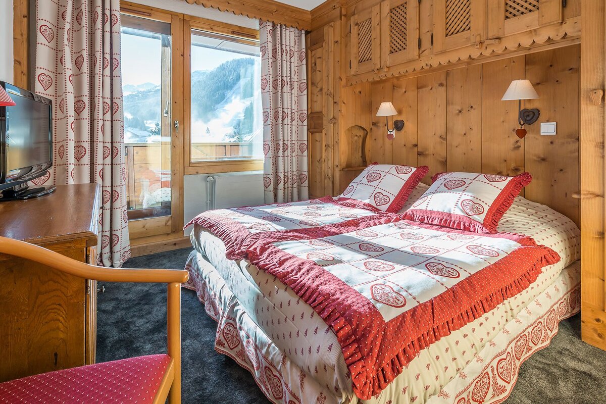 A bedroom with two beds and a flat screen tv