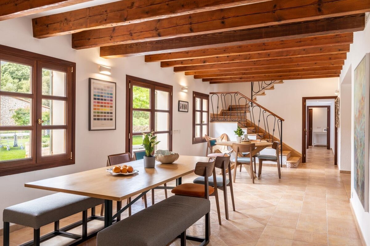 A dining room with a table and chairs and a staircase