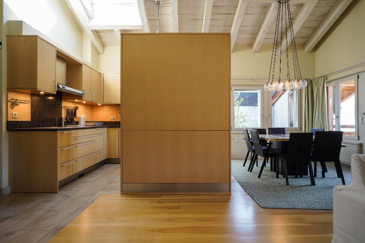 A kitchen with wooden cabinets and a table and chairs
