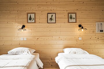 A bedroom with two beds and three pictures on the wall