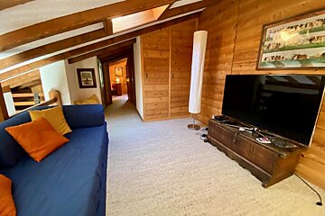 A living room with a blue couch and a flat screen tv